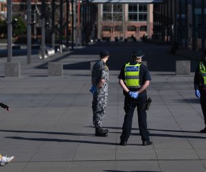 epa08615600 A person wearing a face mask walks past Victoria Police, Airforce and Australian  Defense Force (ADF) personnel outside of the Melbourne Museum in Melbourne, Victoria, Australia, 21 August 2020.  EPA/JAMES ROSS AUSTRALIA AND NEW ZEALAND OUT