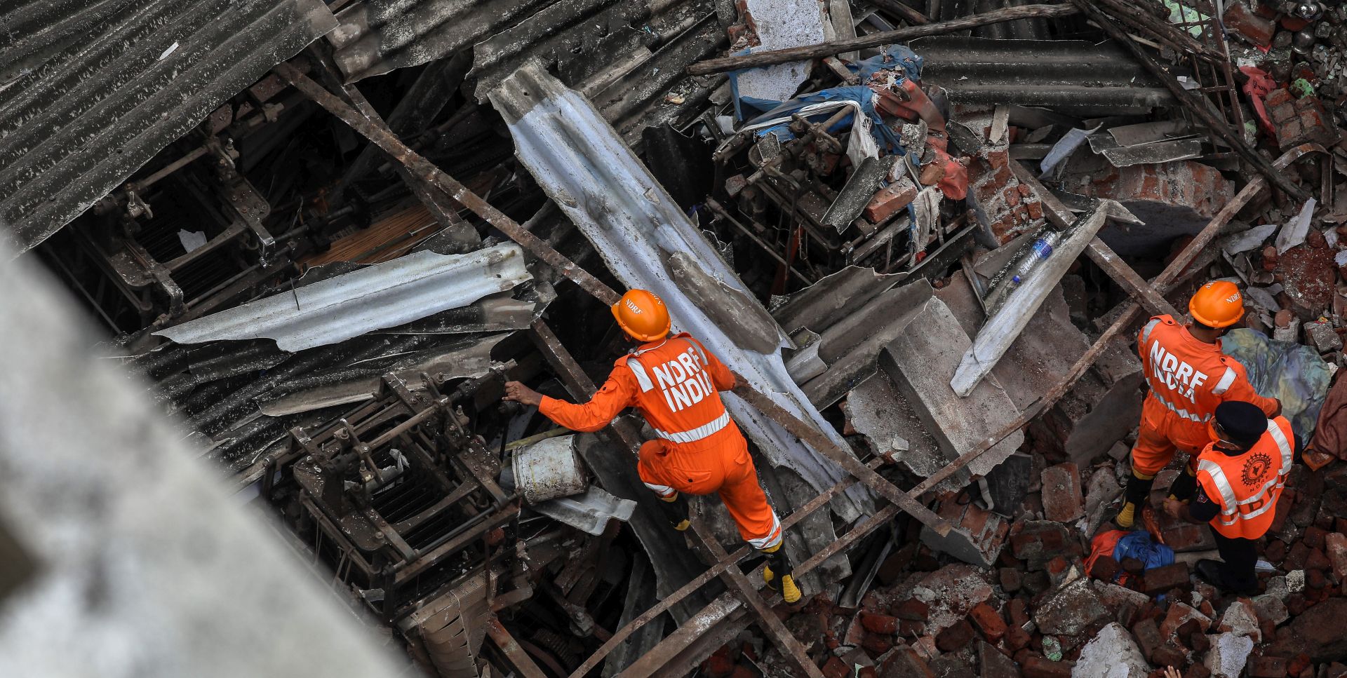epa08685598 National Disaster Response Force (NDRF) personnel work in the aftermath of a residential building's collapse in Bhiwandi, outskirts of Mumbai, India, 21 September 2020. According to reports, at least 10 people died and several are feared to be trapped under the rubble of the three-storey residential building.  EPA/DIVYAKANT SOLANKI