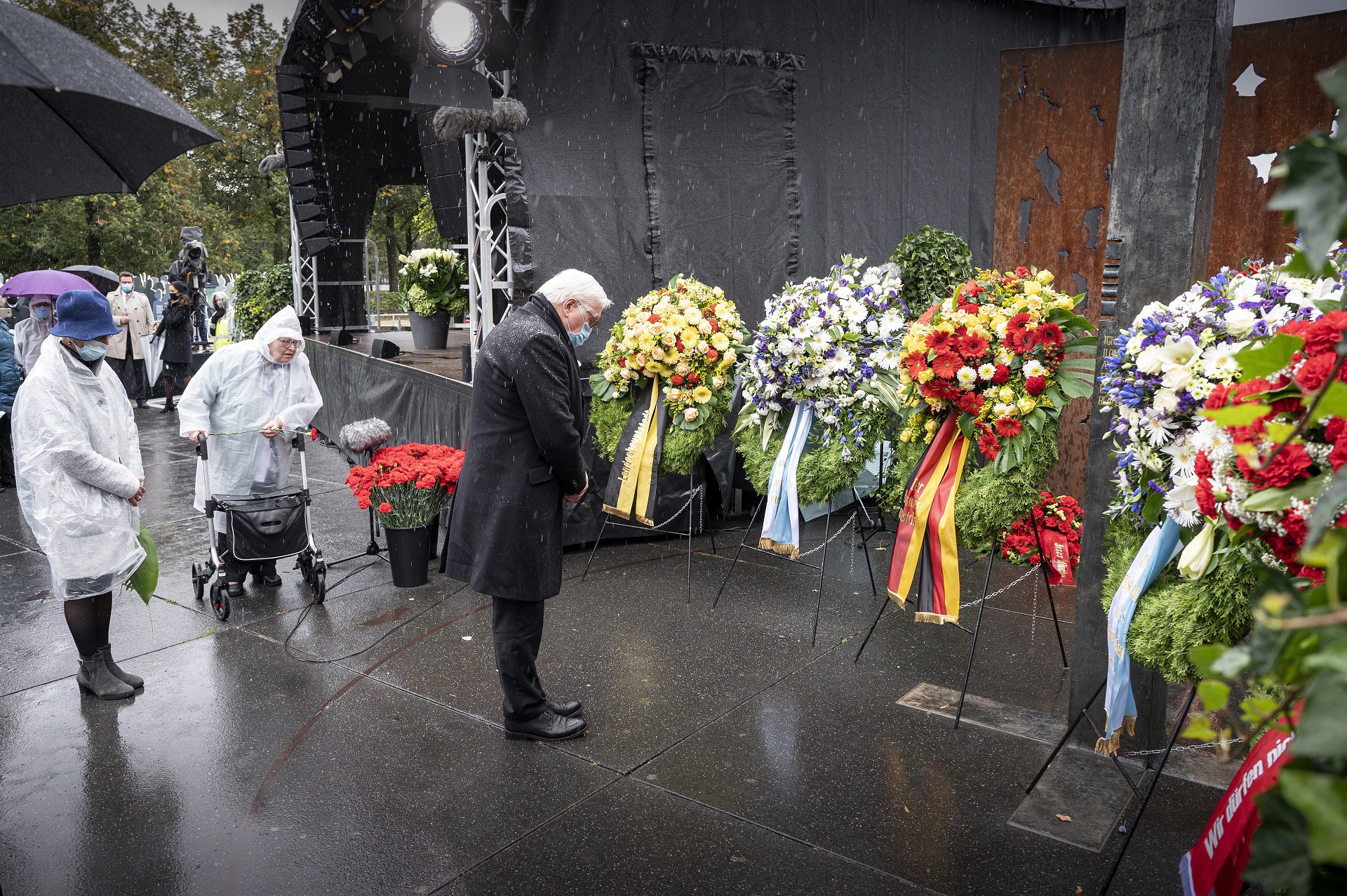epa08698487 A handout photo made available by the German government shows German president Frank-Walter Steinmeier laying wreath next to survivors Gudrun Lang (L) and Renate Martinez (2-L) during a commemoration ceremony at the site of the 40th anniversary of the Oktoberfest bomb attack in Munich, Bavaria, Germany, 26 September 2020. A neo-Nazi blew himself up at Munich's Oktoberfest beer festival in 1980, killing 12 other people.  EPA/Guido Bergmann HANDOUT  HANDOUT EDITORIAL USE ONLY/NO SALES