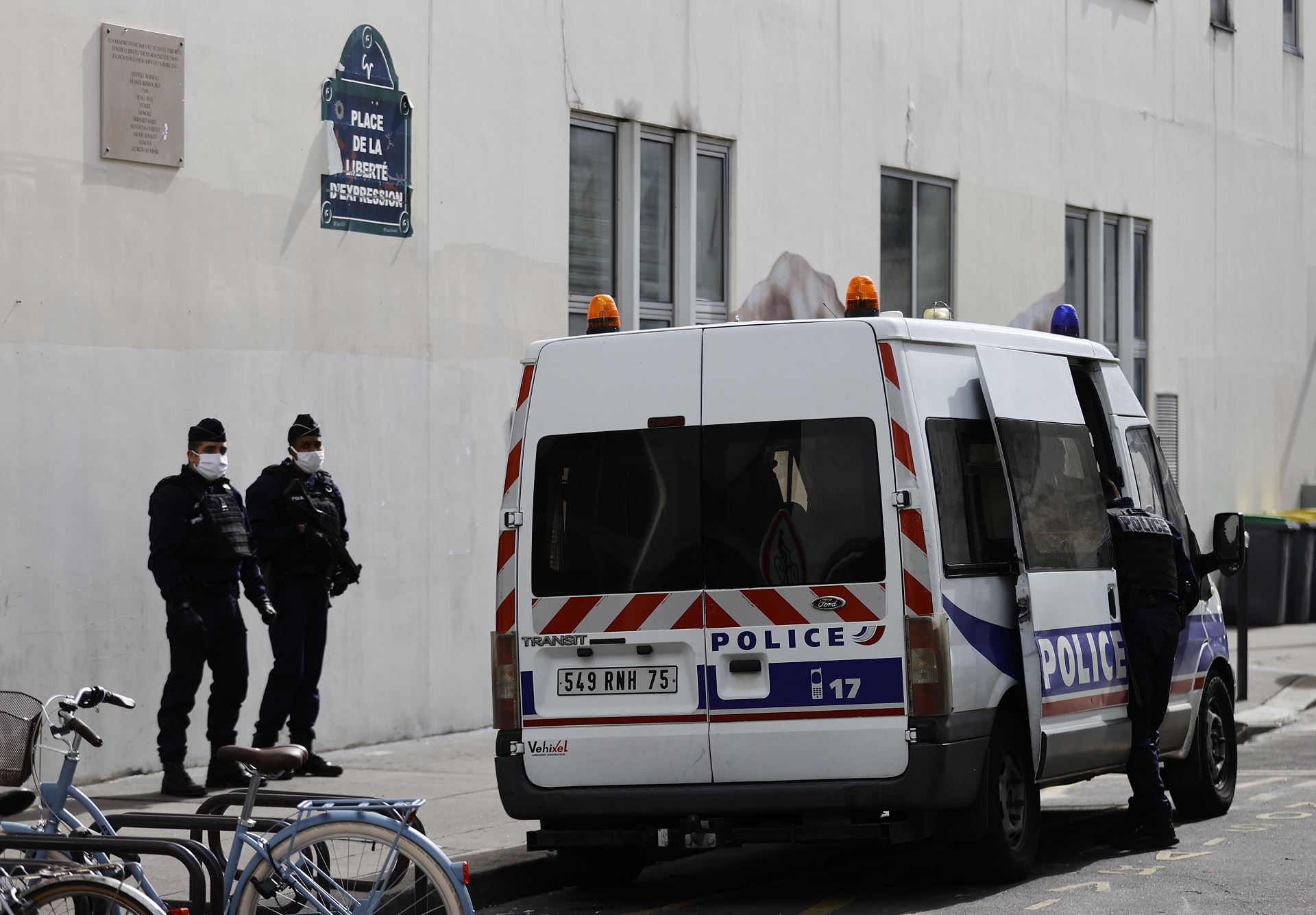 epa08698654 French police officers stand guard in front of the former Charlie Hebdo offices, on Rue Nicolas Appert in Paris, France, 26 September 2020, the day after a knife attack during which two people were wounded. A suspect was later apprehended nearby on Place de la Bastille, and has since revealed he intended to exact revenge for Charlie Hebdo's caricatures.  EPA/IAN LANGSDON