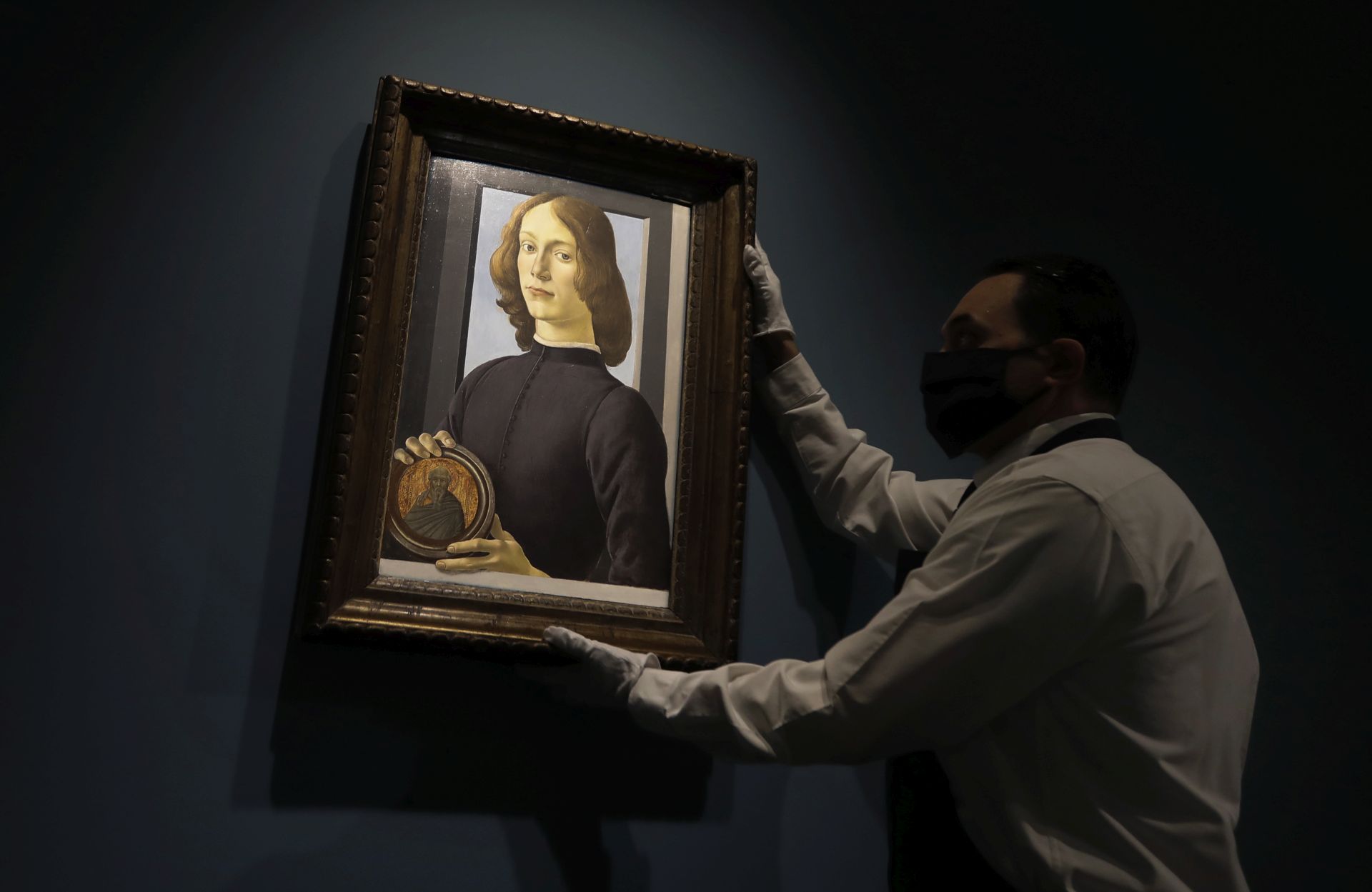 epa08692895 Sandro Botticelli's 15th-century portrait of a 'Young Man Holding a Roundel' is displayed by an employee at Sotheby's Auction house in New York, New York, USA, 23 September 2020 (issued 24 September 2020).The painting is estimated to sell in excess of 80 million US dollars as the main highlight of Sotheby's Masters Week sale. EPA/PETER FOLEY


















estimated to sell in excess of 80 million US dollars as the main highlight of our Masters Week sale  EPA-EFE/Peter Foley