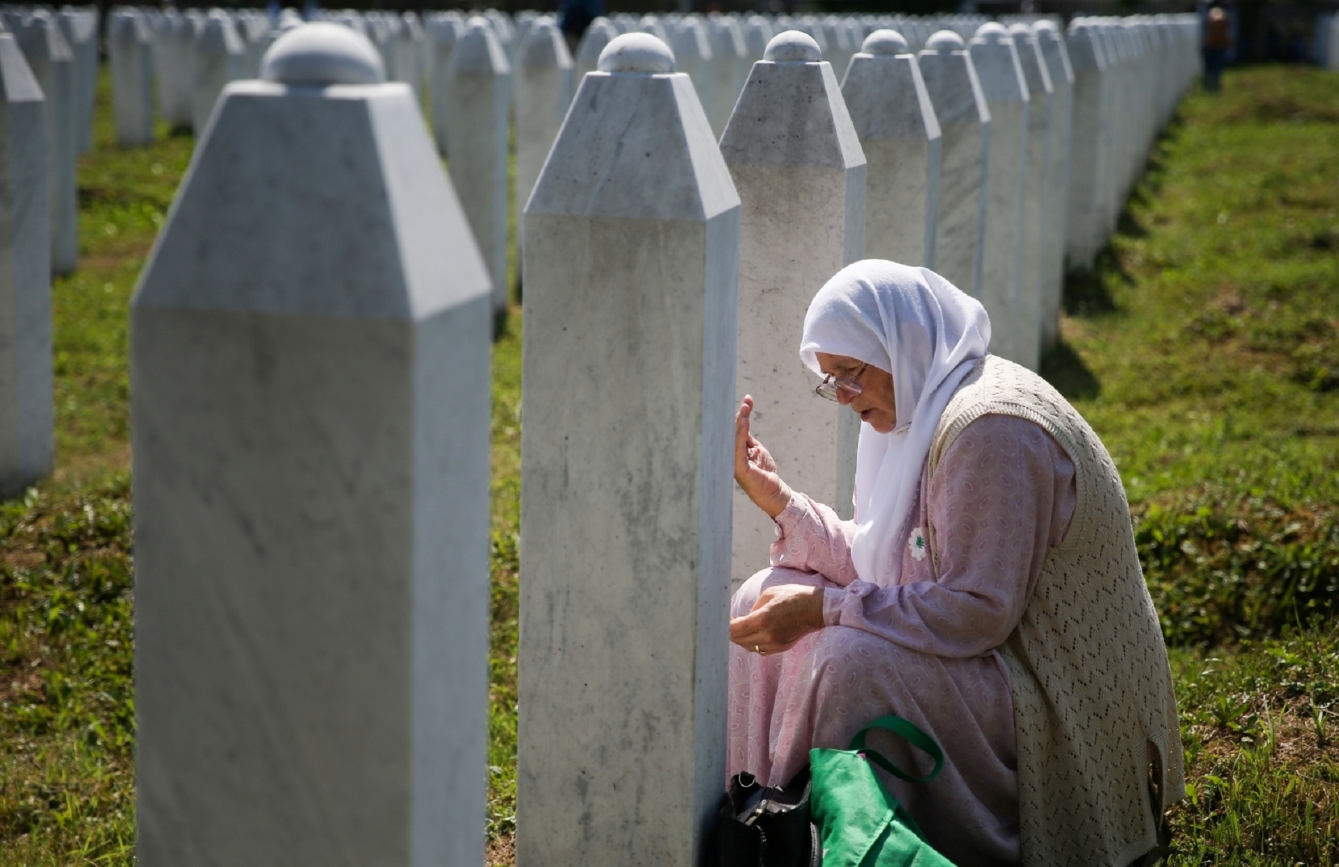 Bosnia and Herzegovina commemorates 25th anniversary of Srebrenica massacre, in Potocari A woman prays at a graveyard, ahead of a mass funeral in Potocari near Srebrenica, Bosnia and Herzegovina July 11, 2020. Bosnia marks the 25th anniversary of the massacre of more than 8,000 Bosnian Muslim men and boys, with many relatives unable to attend due to the coronavirus disease (COVID-19) outbreak. REUTERS/Dado Ruvic DADO RUVIC