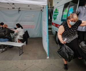 epa08646556 A Russian woman gets out of the ambulance after receiving a free flu vaccine at a mobile vaccination station on a street in Moscow, Russia, 04 September 2020. There are 400 vaccination sites deployed in Moscow, including 40 mobile points.  EPA/YURI KOCHETKOV