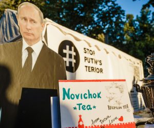 epa08679342 A staged protest in front of the Russian embassy shows a picture of Russian President Vladimir Putin (C), Russian opposition activist Alexei Navalny (L) and a Russian teapot samovar with a note reading 'Novichok tea', 'Kremlin tea' and 'from Russia with love', in Berlin, Germany, 16 September 2020. Navalny is receiving treatment at the Charite hospital in Berlin since 22 August 2020 after being poisoned with a nerve agent from the Novichok group.  EPA/CLEMENS BILAN