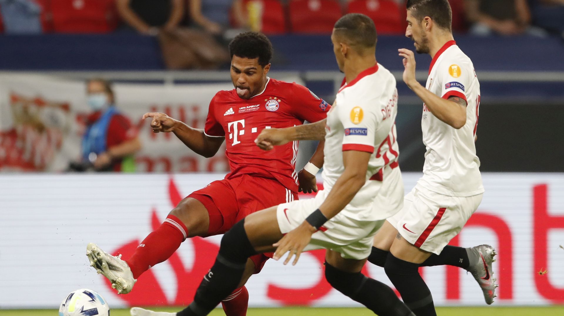 epa08694575 Serge Gnabry (L) of Bayern Munich in action during the UEFA Super Cup final between Bayern Munich and Sevilla at the Puskas Arena in Budapest, Hungary, 24 September 2020.  EPA/Bernadett Szabo / POOL