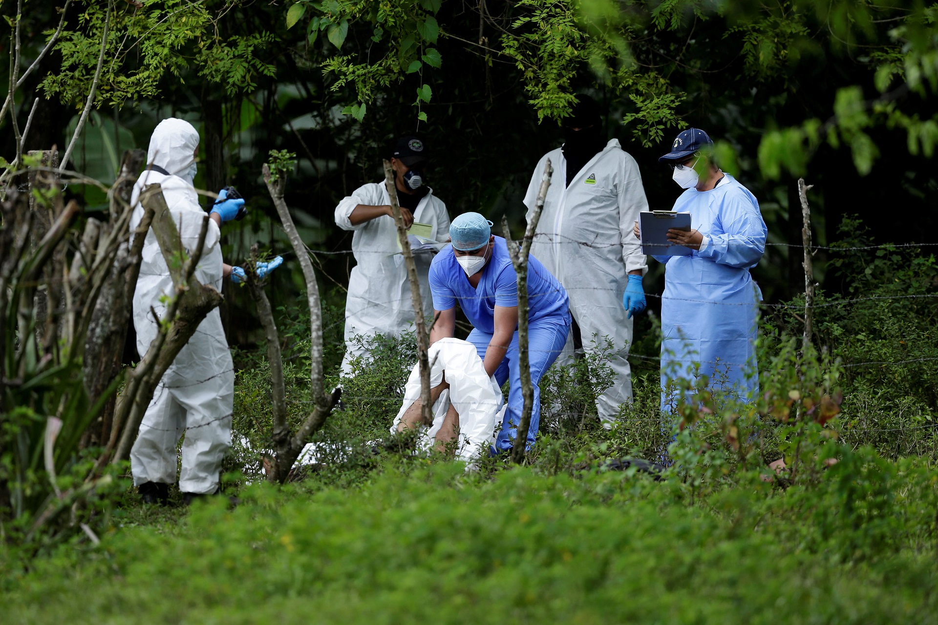 epa08714218 Forensics and police investigators work at the scene where the bodies of five people who were killed were found in San Julian, El Salvador, 01 October 2020. At least five people were killed in a village in the municipality of San Julian, in western El Salvador, the Attorney General's Office (FGR) reported on 01 October. According to the Prosecutor's Office, which shared information provided by the National Civil Police (PNC) in the place, the 'deprivation of liberty' of three people was reported on 30 September and now 'the notice of some deceased persons was received' in the Guacoco village.  EPA/Rodrigo Sura ATTENTION: GRAPHIC CONTENT  EPA-EFE/Rodrigo Sura ATTENTION: GRAPHIC CONTENT
