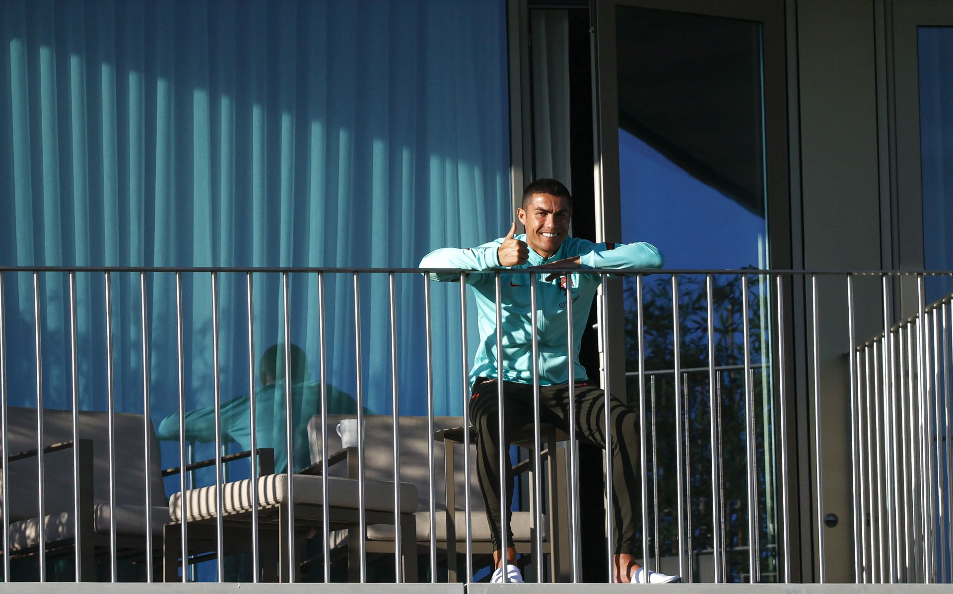 epa08741439 A handout photo made available by Portuguese Football Federation (FPF) shows Portugal national soccer team player Cristiano Ronaldo in the balcony of his room during his team training session for the upcoming UEFA Nations League soccer match with Sweden, Lisbon, Portugal, 13 October 2020. On 13 October 2020 the Portuguese Football Federation announced that Cristiano Ronaldo tested positive for COVID-19 coronavirus. Ronaldo is isolated and asymptomatic.  EPA/DIOGO PINTO / HANDOUT  HANDOUT EDITORIAL USE ONLY/NO SALES