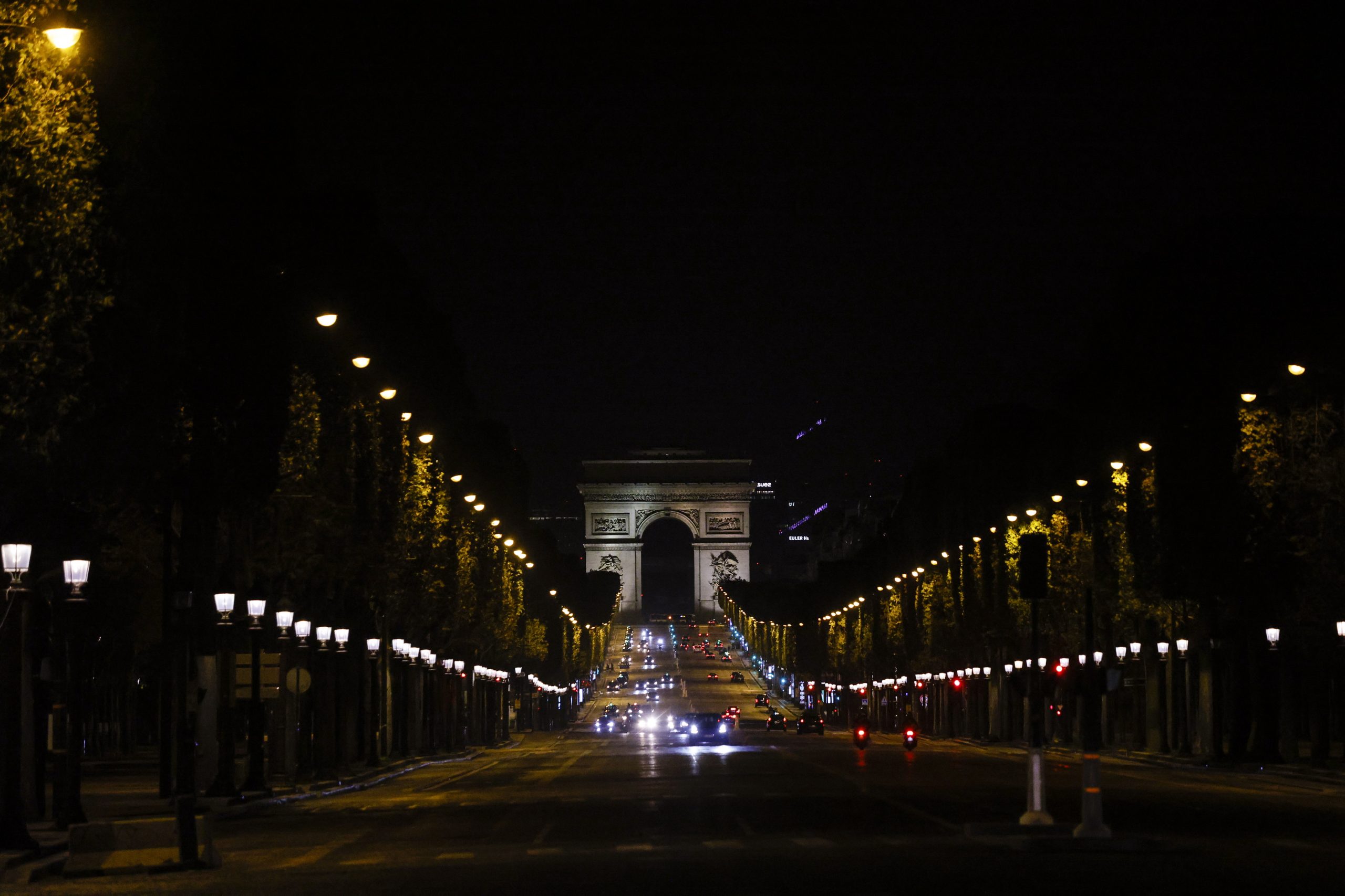 epa08754323 Few cars ride on the Champs Elysees avenue during a city-wide night time curfew goes into effect in Paris, France, 17 October 2020. French President Emmanuel Macron announced on 14 October that a curfew would be established for a minimum duration of four weeks in Paris and eight other cities across France to reduce the spread of COVID-19 after a surge in cases of coronavirus across the country. The curfew prohibits leaving one's house between 9pm and 6am unless a valid motive is presented.  EPA/YOAN VALAT