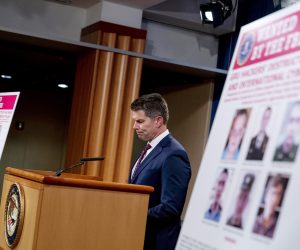 epa08757960 Posters showing six wanted Russian military intelligence officers are displayed as FBI Deputy Director David Bowdich pauses while speaking at a news conference at the Department of Justice, in Washington, DC, USA, 19 October 2020.  EPA/Andrew Harnik / POOL