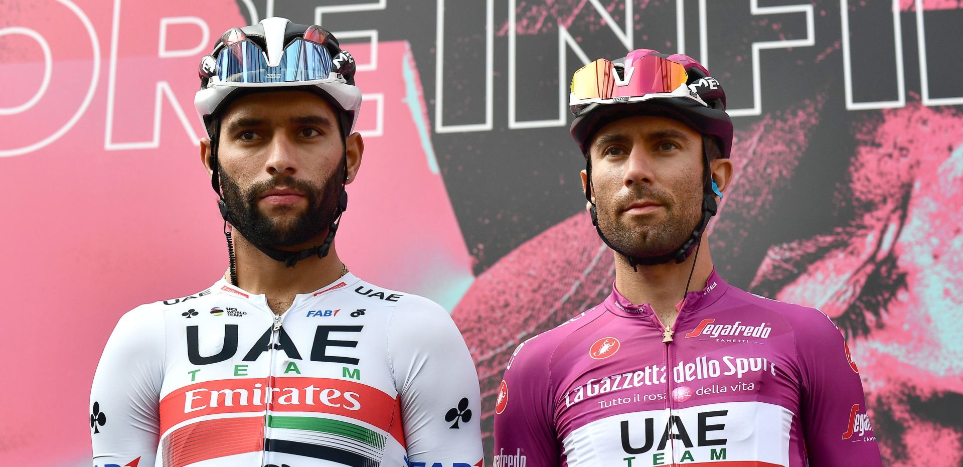 epa08724087 Italian rider Diego Ulissi (R) of UAE-Team Emirates in the points classification leader's cyclamen jersey and his Colombian team mate Fernando Gaviria attend the sign in ceremony before the 4th stage of the 2020 Giro d'Italia cycling race over 140 km from Catania to Villafranca Tirrena in Sicily, Italy, 06 October 2020.  EPA/LUCA ZENNARO