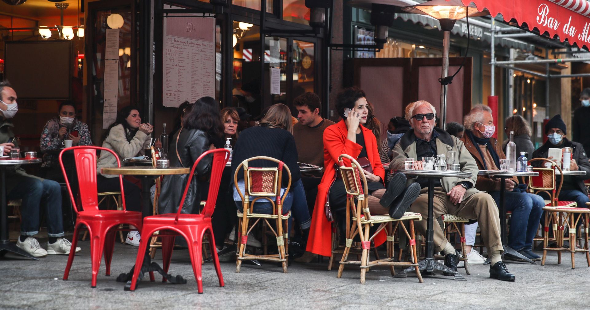 epa08783214 People sit on the terrasse of a restaurant in Paris, France, 29 October 2020. French President Emmanuel Macron announced a return to lockdown, dubbed 'reconfinement' to come into effect on 30 October 2020 as new measures to battle the rise in Covid-19 cases.  EPA/MOHAMMED BADRA