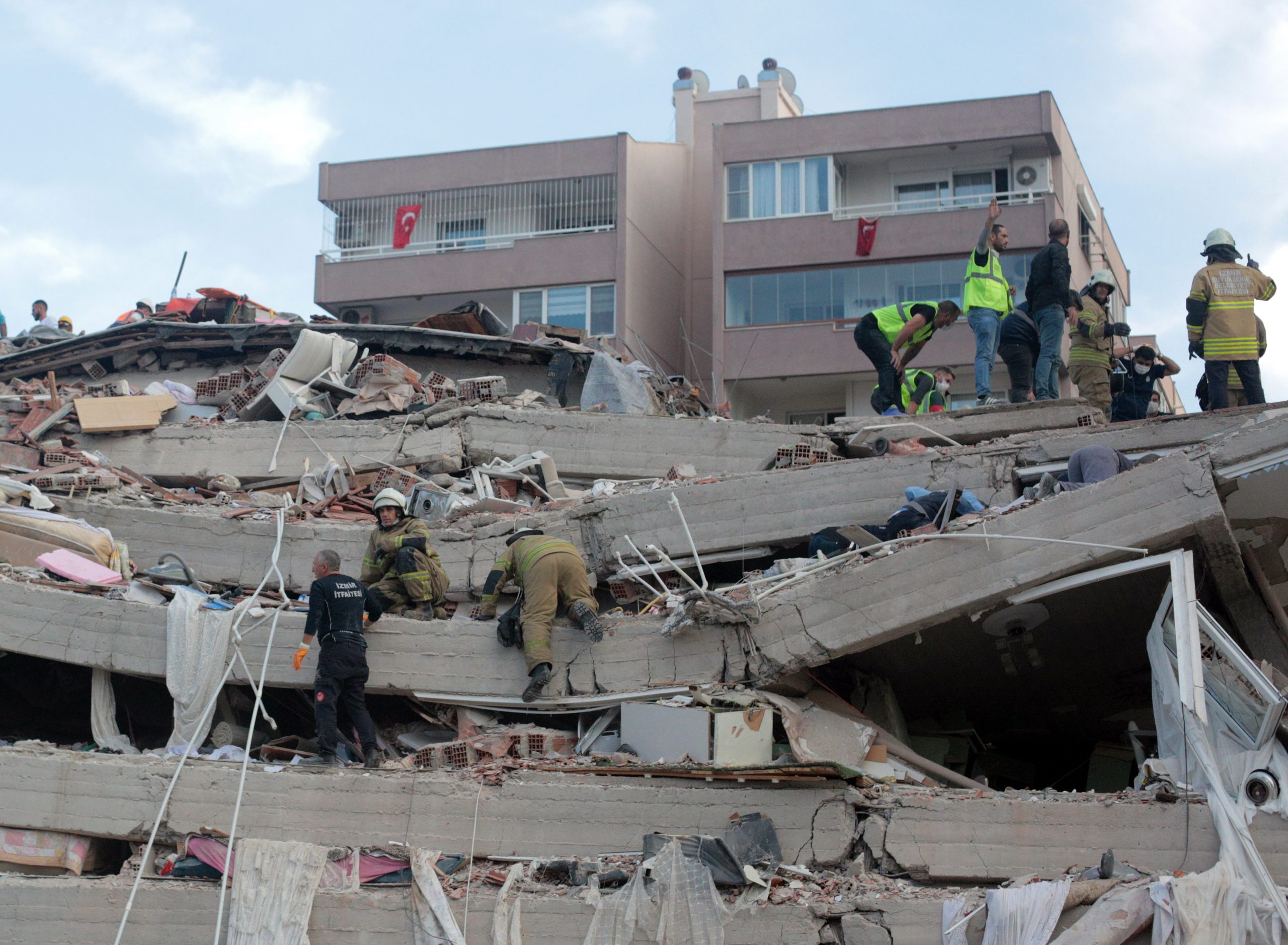 epa08786511 Rescue workers and people search for survivors at a collapsed building after a 7.0 magnitude earthquake in the Aegean Sea in Izmir, Turkey, 30 October 2020. According to Turkish media reports, at least six people died while hundreds were injured and dozens of buildings were destroyed in the earthquake.  EPA/STRINGER