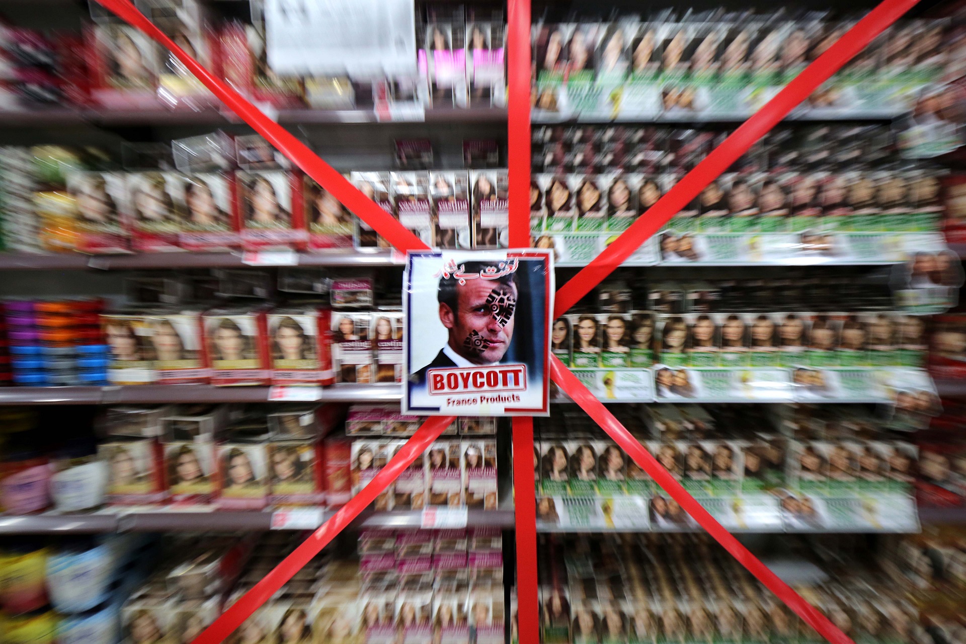 epaselect epa08786094 Picture of French President Macron is posted next to a message 'Boycott French products' at supermarket to protest against French President Macron's comments over Prophet Muhammad caricatures, in Peshawar, Pakistan, 30 October 2020. Calls for boycotting French products spread in several countries in response to French President Emmanuel Macron's comments that his country would not give up publishing Prophet Muhammad’s cartoons following the recent beheading of a teacher in France after he had shown such cartoons in class.  EPA/BILAWAL ARBAB