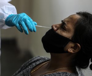 epa08767384 An Indian health worker takes a nasal swab sample of an employee working at Film City, in Mumbai, India, 23 October 2020. According to reports, India became the second worst-hit country by the spread of novel coronavirus which causes Covid-19 disease, as Indian tally rose to over 7.7 million cases, only behind the United States.  EPA/DIVYAKANT SOLANKI