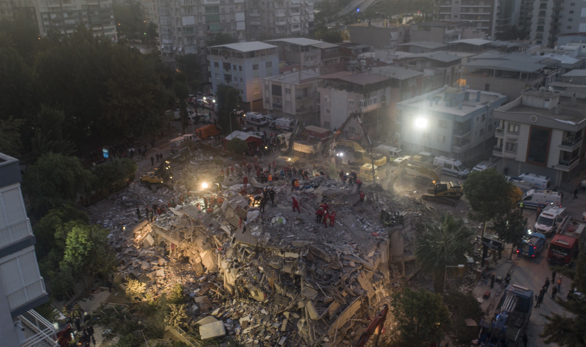 epa08787347 An aerial photo made with a drone shows rescue workers and people search for survivors at a collapsed building after a 7.0 magnitude earthquake in the Aegean Sea, at Bayrakli district in Izmir, Turkey, 31 October 2020. According to Turkish media reports, at least twenty four people died while more than eight hundred were injured and dozens of buildings were destroyed in the earthquake.  EPA/ERDEM SAHIN