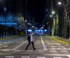 epa08776815 A resident crosses the Via Laietana street during the second day of the curfew in Barcelona, northeastern Spain, late night 26 October 2020. A curfew and some other measures were implemented in the region to try to contain the spreading of COVID-19 virus disease.  EPA/Quique Garcia