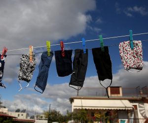 epa08807129 Face masks hang to dry from a rope between terraces in Athens, Greece, 08 November 2020. New restrictions have been enforced in Athens amid a second wave of COVID-19 infections sweeping through Europe.  EPA/ORESTIS PANAGIOTOU