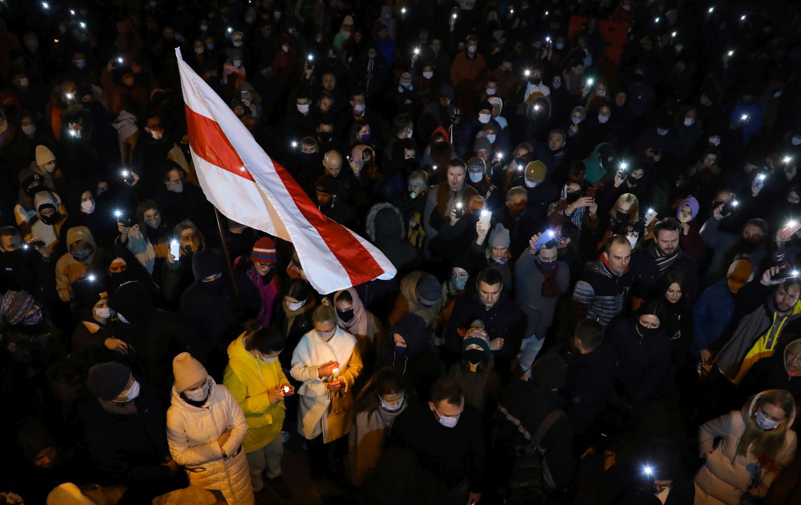 epa08816768 Belarusians light phones, as they bring candles at Change Square to commemorate Roman Bondarenko in Minsk, Belarus, late 12 November 2020. A 31-year-old Roman Bondarenko was reportedly injured by masked men on late 11 November in such a way that he died in hospital later.  EPA/STR