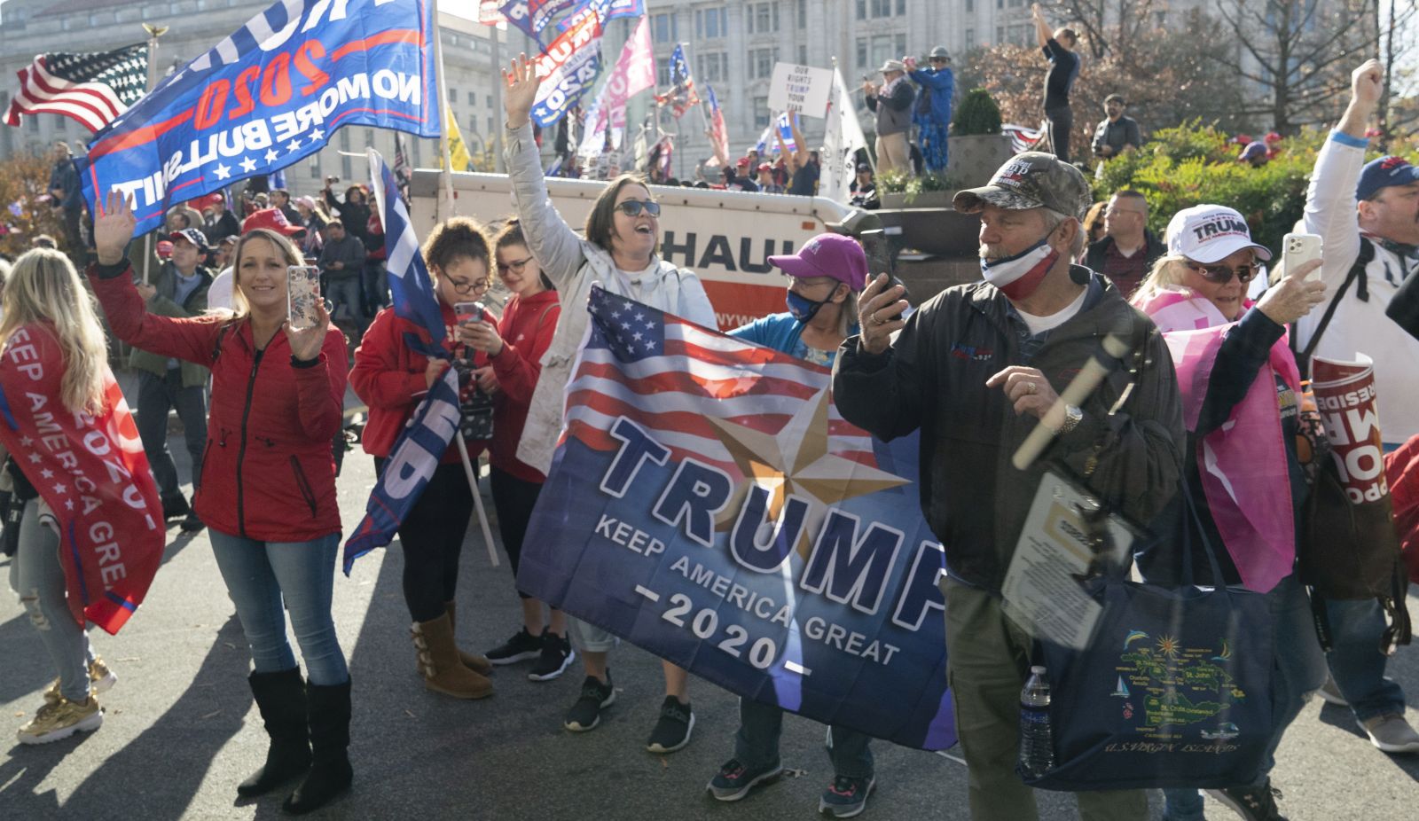 epa08820050 Trump supporters demonstrate as the motorcade carrying U.S. President Donald J. Trump drives through a rally of while departing the White House, headed out to an undisclosed location in Washington, DC, USA, 14 November 2020.  EPA/CHRIS KLEPONIS / POOL