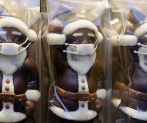 epa08838600 Chocolate Santa Clauses with face masks stand in a confectionery shop during the coronavirus pandemic in Frankfurt am Main, Germany, 24 November 2020. Due to an increasing number of cases of the pandemic COVID-19 disease caused by the coronavirus SARS CoV-2, nationwide restrictions have been announced to counter a surge in infections, such as the closure of bars and restaurants.  EPA/RONALD WITTEK