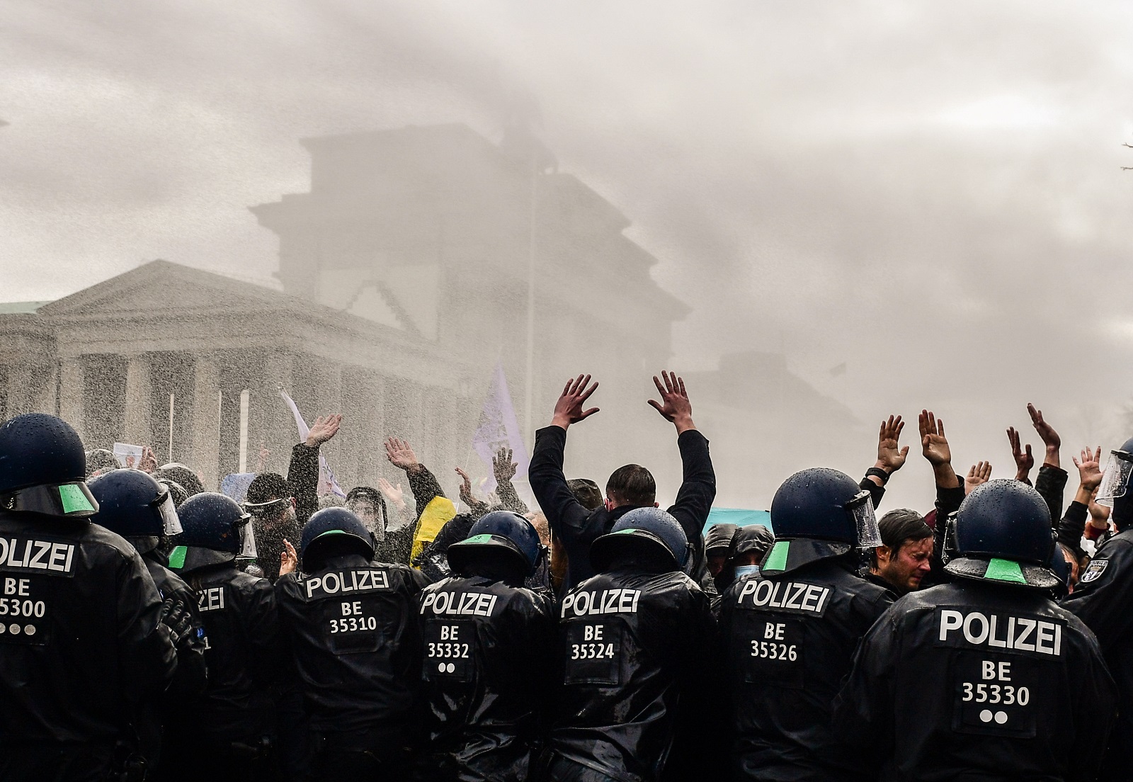 epa08827865 Riot police uses a water cannon to break up a demonstration against German coronavirus restrictions, near the Brandenburg Gate in Berlin, Germany, 18 November 2020. While German interior minister prohibited demonstrations around the Reichstag building during the parliamentary Bundestag session, people gathered to protest against government-imposed semi-lockdown measures aimed at curbing the spread of the coronavirus pandemic. Since 02 November, all restaurants, bars, cultural venues, fitness studious, cinemas and sports halls are forced to close for four weeks as a lockdown measure to rein in skyrocketing coronavirus infection rates.  EPA/FILIP SINGER