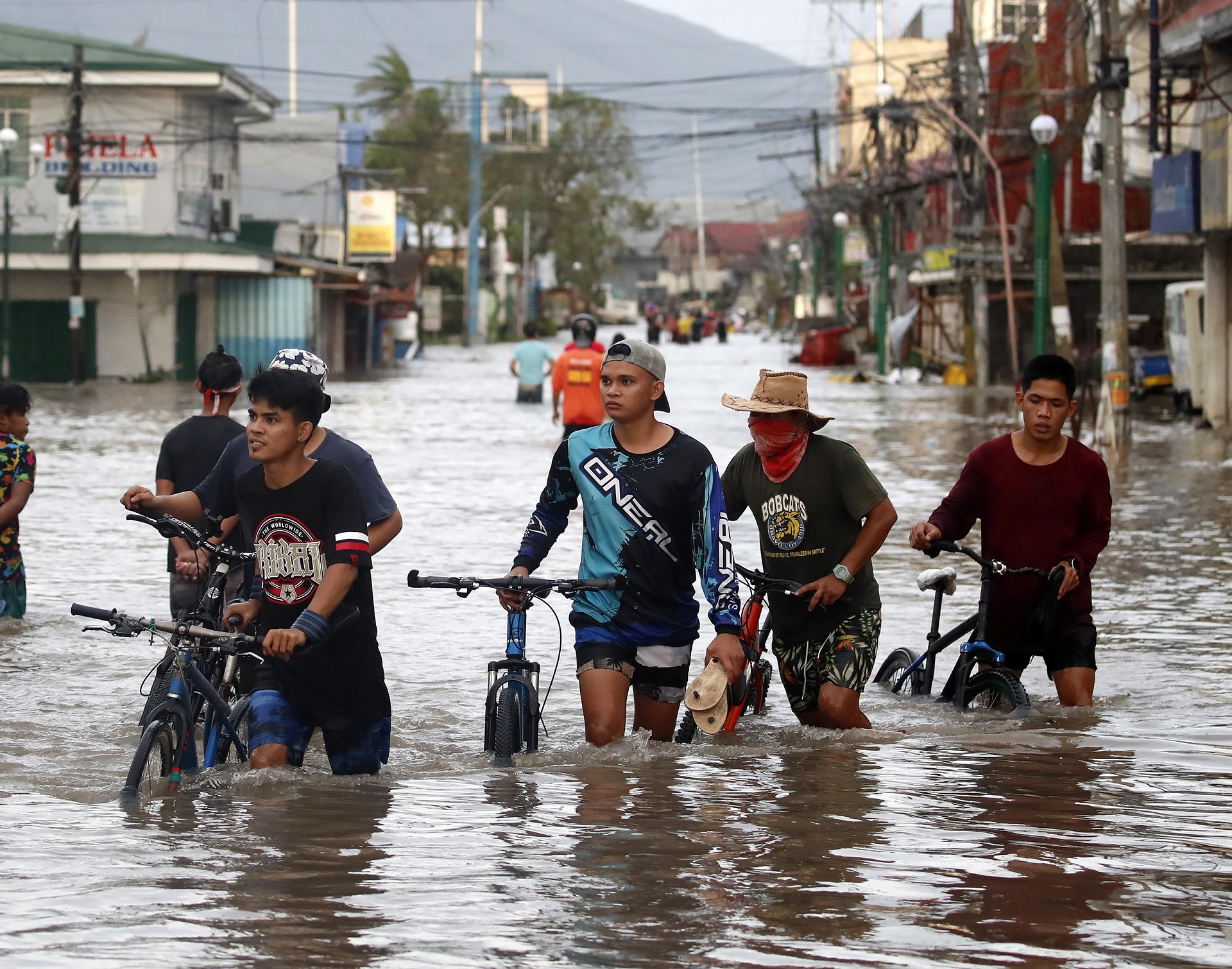 epa08790397 Filipino villagers wade along a flooded road in the typhoon-hit town of Nabua, Camarines Sur, Philippines, 01 November 2020. Super Typhoon Goni, with winds forecasted to reach over 240 kilometers per hour, made landfall on 01 November 2020, in the Philippine provinces of Albay, Camarines Sur and Quezon.  EPA/FRANCIS R. MALASIG