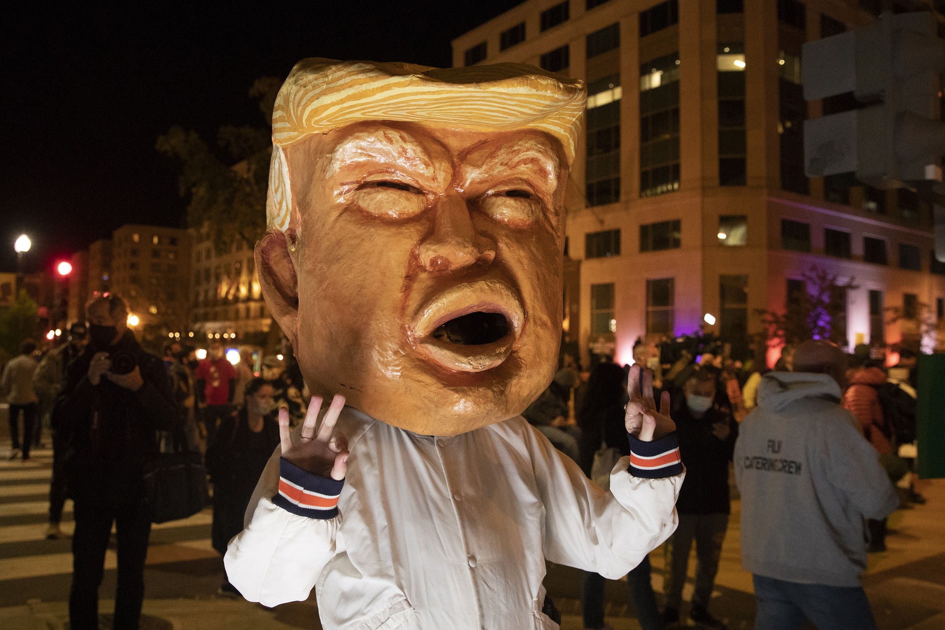 epa08797277 A woman wears a mask depicting US President Donald J. Trump at Black Lives Matter Plaza in Washington, DC, USA, 03 November 2020. Americans vote on Election Day to choose between re-electing Donald J. Trump or electing Joe Biden as the 46th President of the United States to serve from 2021 through 2024.  EPA/MICHAEL REYNOLDS