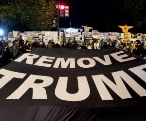 epa08797255 People hold a banner that reads 'Remove Trump', at Black Lives Matter Plaza near the White House, seen behind, in Washington, DC, USA, 03 November 2020. Americans vote on Election Day to choose between re-electing Donald J. Trump or electing Joe Biden as the 46th President of the United States to serve from 2021 through 2024.  EPA/MICHAEL REYNOLDS