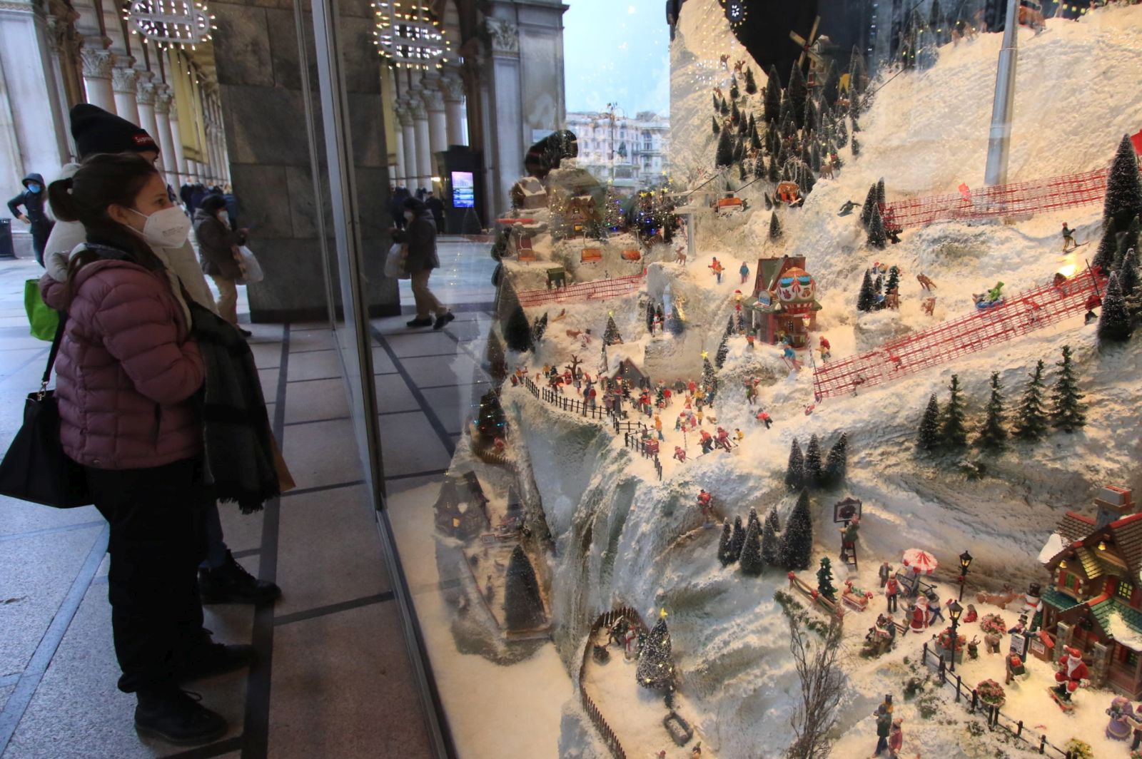 epa08854455 People look at a Christmas crib with wintersport and skiing related details set up in a window of the Rinascente store in Duomo Square in Milan, Italy, as people do their pre-Christmas shopping on 01 December 2020. Italian Prime Minister Giuseppe Conte already in November called on Italians not to ski during the Christmas holidays in order to curb the spread of the coronavirus during the second wave of the pandemic.  EPA/PAOLO SALMOIRAGO