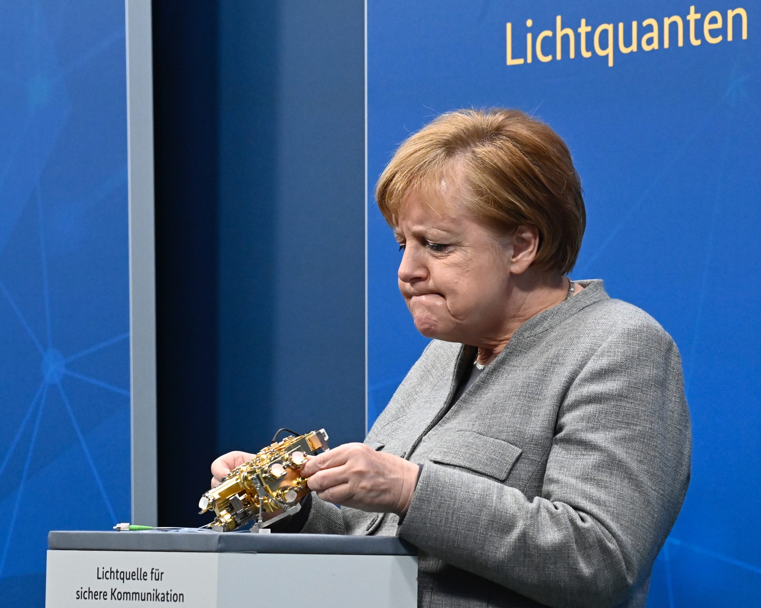 epa08854642 German Chancellor Angela Merkel looks at a light engine for secure communication as she takes part in the virtual Digital Summit 2020 at the Chancellery in Berlin, Germany, 01 December 2020.  EPA/TOBIAS SCHWARZ / POOL