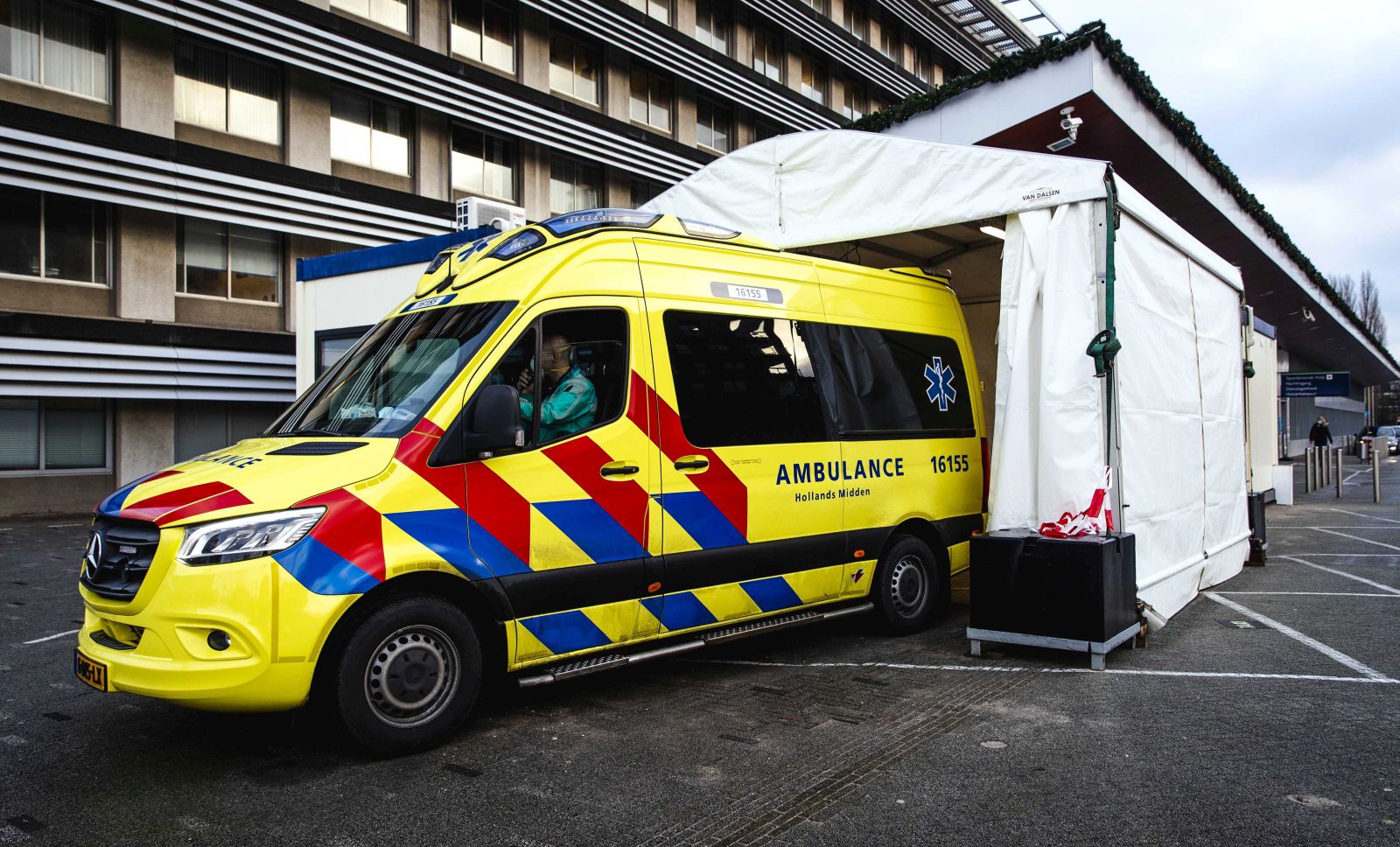 epa08889871 An ambulance at a medical cabin at the emergency department of the Groene Hart Hospital, where corona suspected patients are received in Gouda, the Netherlands, 17 December 2020. The temporary cabin is to separate patients with and without corona as they are admissioned to the hospital.  EPA/SEM VAN DER WAL