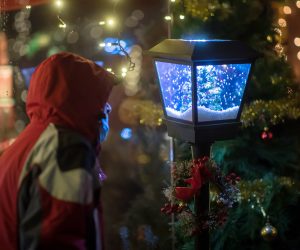 epa08896875 A visitor checks a decoration at a traditional Christmas market in front of the entrance to the Wieliczka Salt Mine, in Wieliczka, Poland, 20 December 2020.  EPA/LUKASZ GAGULSKI POLAND OUT
