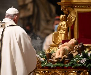 epa08902986 Pope Francis kisses a figurine of baby Jesus during a Christmas Eve mass to mark the nativity of Jesus Christ, at St Peter's basilica in the Vatican, 24 December 2020.  EPA/VINCENZO PINTO / POOL