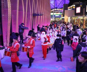 epa08903476 A person dressed as Santa Claus (C) and entertainers parade to celebrate Christmas Day outside a shopping complex in Beijing, China, 25 December 2020. Christmas traditions in China's capital Beijing have become cherished not only among foreigners but locals as well.  EPA/WU HONG