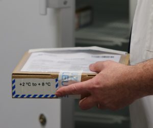 epa08907187 A staff holds a package containing the vaccine as the Covid-19 vaccination campaign continues with the distribution of Pfizer-BioNTech Covid-19 disease vaccines at the UZ Leuven hospital in Leuven, Belgium, 28 December 2020. The thawed mRNA vaccines, along with the syringes, needles and solvent to dissolve the vaccines, are moved to residential care centers in Brussels, Flanders and Wallonia to be administered to residents.  EPA/OLIVIER MATTHYS / POOL