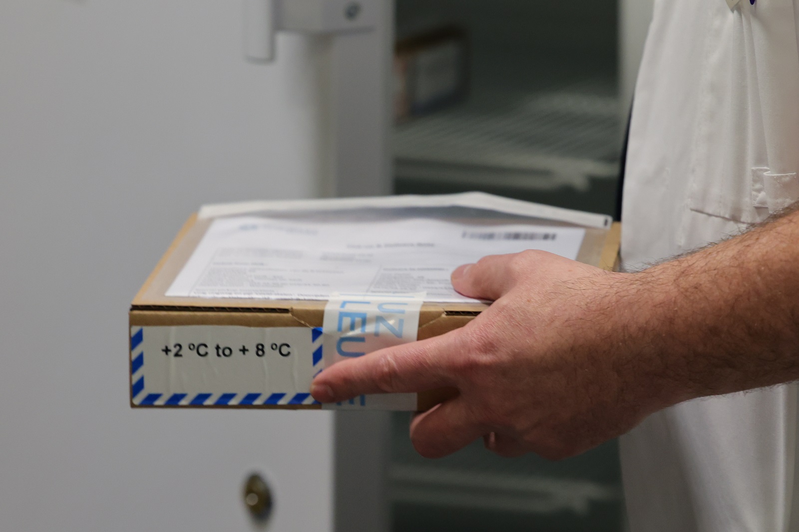 epa08907187 A staff holds a package containing the vaccine as the Covid-19 vaccination campaign continues with the distribution of Pfizer-BioNTech Covid-19 disease vaccines at the UZ Leuven hospital in Leuven, Belgium, 28 December 2020. The thawed mRNA vaccines, along with the syringes, needles and solvent to dissolve the vaccines, are moved to residential care centers in Brussels, Flanders and Wallonia to be administered to residents.  EPA/OLIVIER MATTHYS / POOL
