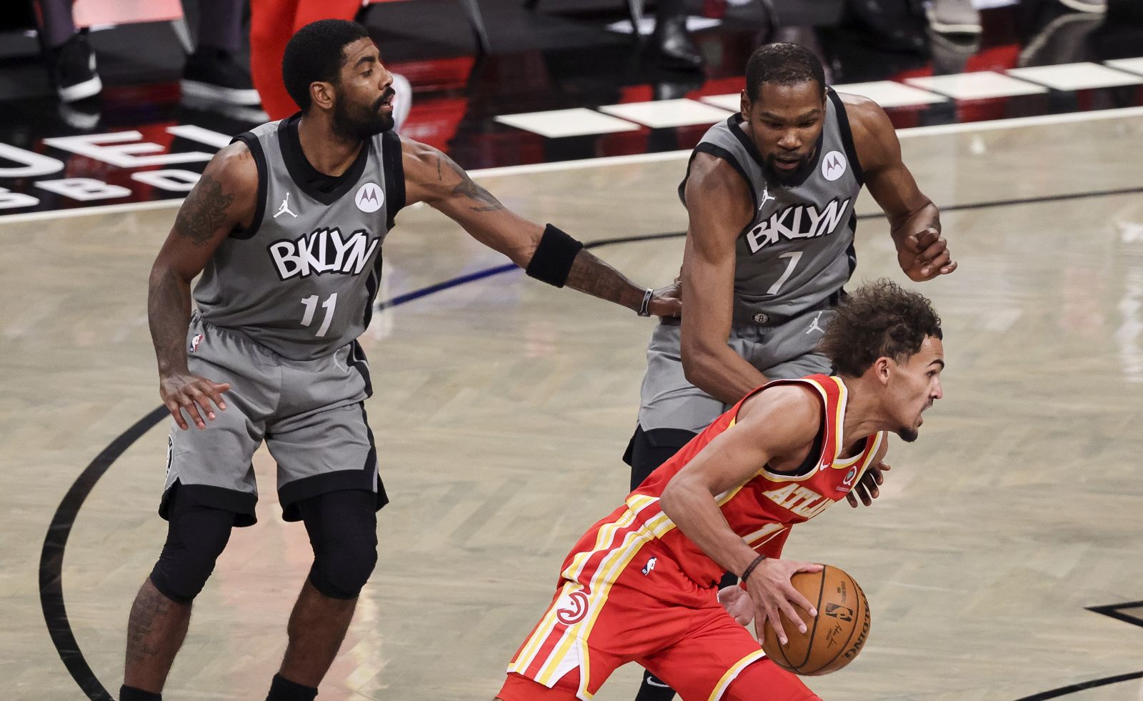 epa08912035 The Hawks' Trae Young (R) drive past the Nets' Kyrie Irving (L) and Kevin Durant (C) during the first half of the game between the Atlanta Hawks and the Brooklyn Nets at the Barclays Center in Brooklyn, New York, USA, 30 December 2020.  EPA/JUSTIN LANE SHUTTERSTOCK OUT
