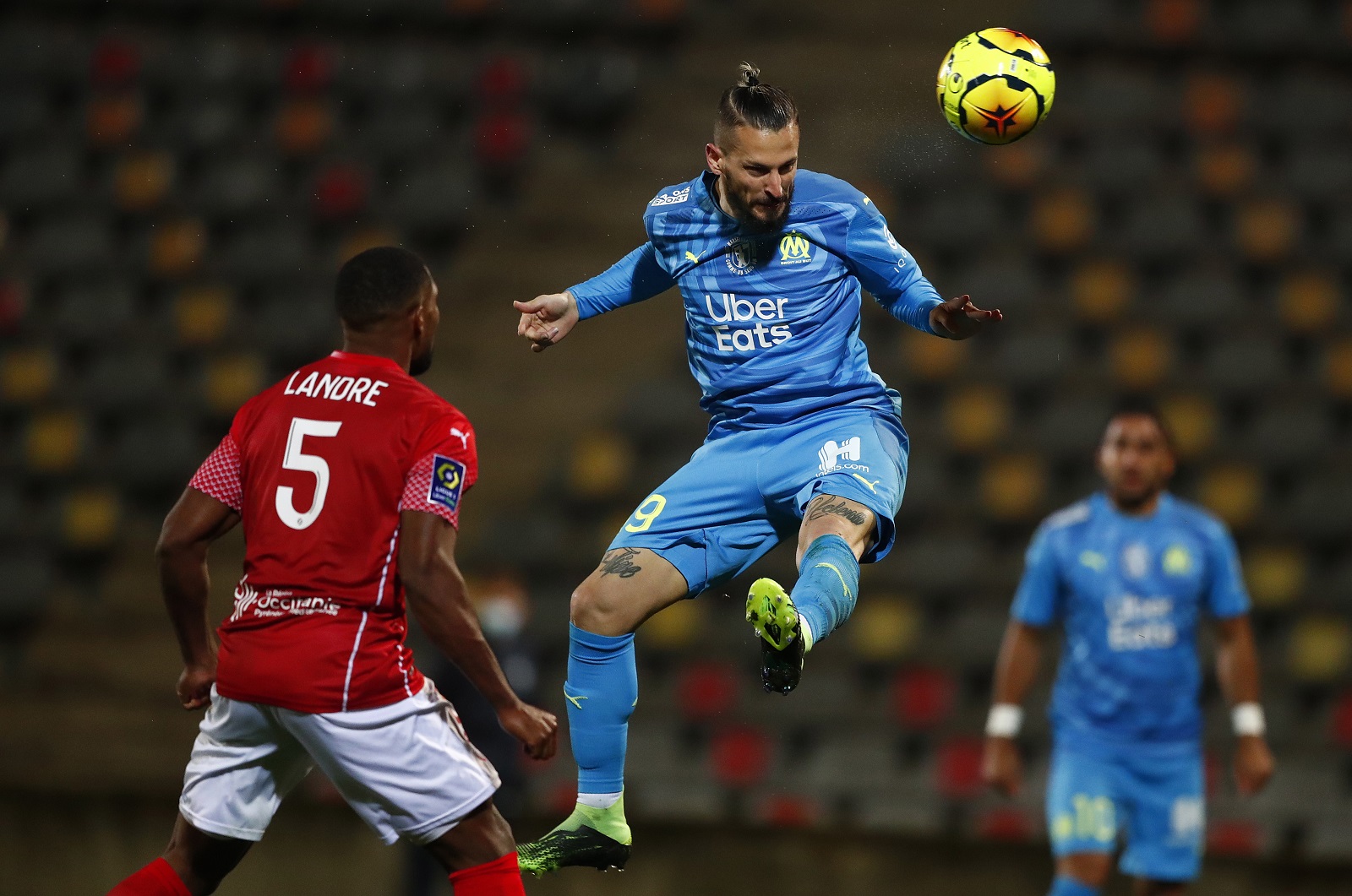 epa08862967 Dario Benedetto (R) of Olympique Marseille and Lucas Deaux (L) of Nimes Olympique in action during the French Ligue 1 soccer match between Nimes Olympique and Olympique Marseille, in Nimes, France, 04 December 2020.  EPA/Guillaume Horcajuelo