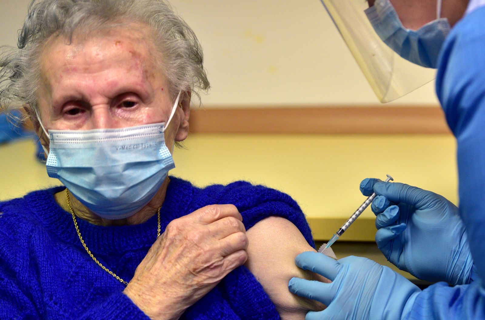 epa08905639 A Slovenian patient (L) receives a vaccine of the Pfizer-BioNTech against the COVID-19 at the Home for Elderly people Fuzine, in Ljubljana, Slovenia, 27 December 2020.  EPA/IGOR KUPLJENIK