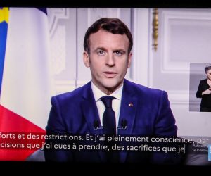 epa08912999 A screen displays French President Emmanuel Macron delivering his New Year wishes for the year 2021 to the French, in Paris, France, 31 December 2020.  EPA/Mohammed Badra