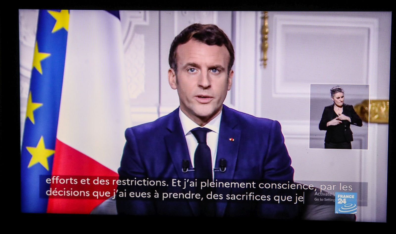 epa08912999 A screen displays French President Emmanuel Macron delivering his New Year wishes for the year 2021 to the French, in Paris, France, 31 December 2020.  EPA/Mohammed Badra