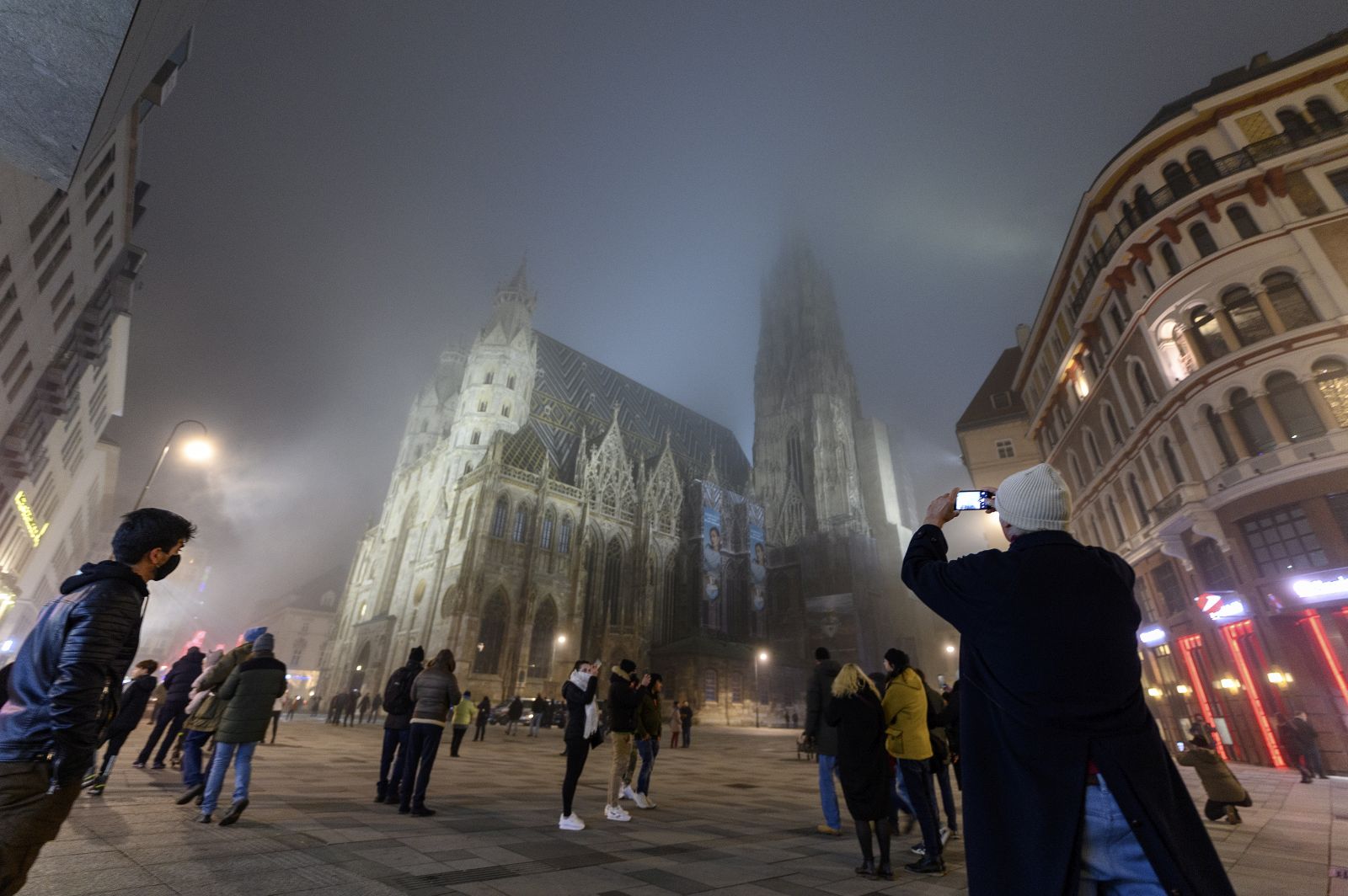 epa08913433 People gather to celebrate the New Year’s Eve at the Stephansplatz square in front of the Saint Stephen's Cathedral during a nationwide COVID-19 lockdown in Vienna, Austria, 31 December 2020.  EPA/CHRISTIAN BRUNA
