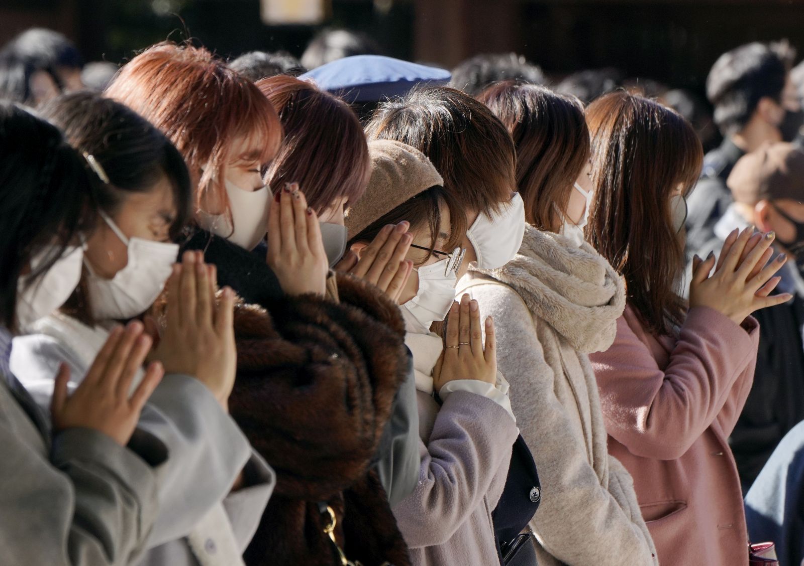 epa08913657 Visitors pray for their health, property and a good future during their first visit of the new year at Meiji Shrine in Tokyo, Japan, 01 January 2021. Annually, more than three million people visit Meiji Shrine during the first three days of the New Year.  EPA/KIMIMASA MAYAMA