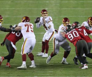 epa08929470 Washington Football Team quarterback Taylor Heinicke (C) drops back to pass against the Tampa Bay Buccaneers during the third quarter of their NFC Wild Card game at FedEx Field in Landover, Maryland, USA, 09 January 2021.  EPA/MICHAEL REYNOLDS