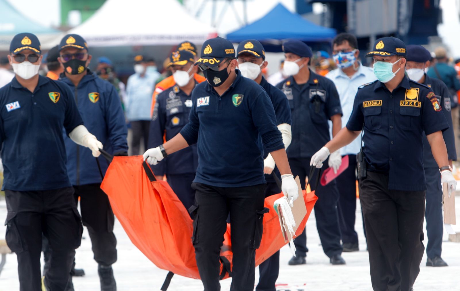 epa08932367 Members of Disaster Victim Investigation (DVI) carry a body bag  at Tanjung Priok port in Jakarta, Indonesia, 12 January 2021. Contact to Sriwijaya Air flight SJ182 was lost on 09 January 2021 shortly after the aircraft took off from Jakarta International Airport while en route to Pontianak in West Kalimantan province. The plane crashed into the sea off the Jakarta coast  EPA/ADI WEDA