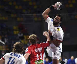 epa08938042 France's Timothey N'Guessan (R) in action against Norway's Petter overby (C) during the match between Norway and France at the 27th Men's Handball World Championship in Cairo, Egypt, 14 January 2021.  EPA/Anne-Christine Poujoulat / POOL