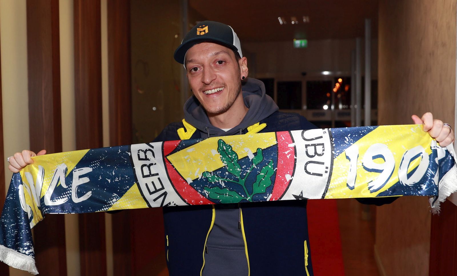 epa08945620 A handout photo made available by Fenerbahce soccer club shows soccer player Mesut Oezil posing with a Fenerbahce scarf upon his arrival to Istanbul, Turkey, 18 January 2021. 32-year-old German World Cup winner Mesut Oezil made an agreement with Arsenal to terminate his contract in order to complete his transfer to Fenerbahce.  EPA/-  HANDOUT EDITORIAL USE ONLY/NO SALES