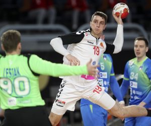 epa08951772 Nenad Kosteski (R) of North Macedonia in action against goalkepeer Urban Lesjak (L) of Slovenia during the match between North Macedonia and Slovenia at the 27th Men's Handball World Championship in Cairo, Egypt, 20 January 2021.  EPA/Mohamed Abd El Ghany / POOL