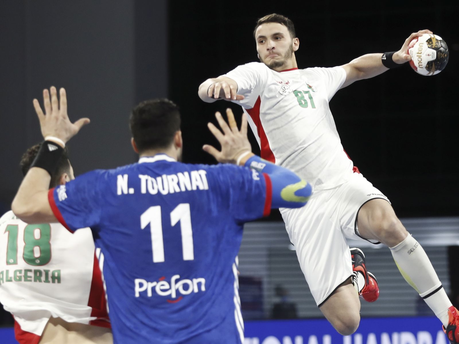 epa08952694 Algeria's Abdi Ayoub (R) in action against France's Nicolas Tournat (C) during the match between France and Algeria at the 27th Men's Handball World Championship in Cairo, Egypt, 20 January 2021.  EPA/Petr Josek / POOL