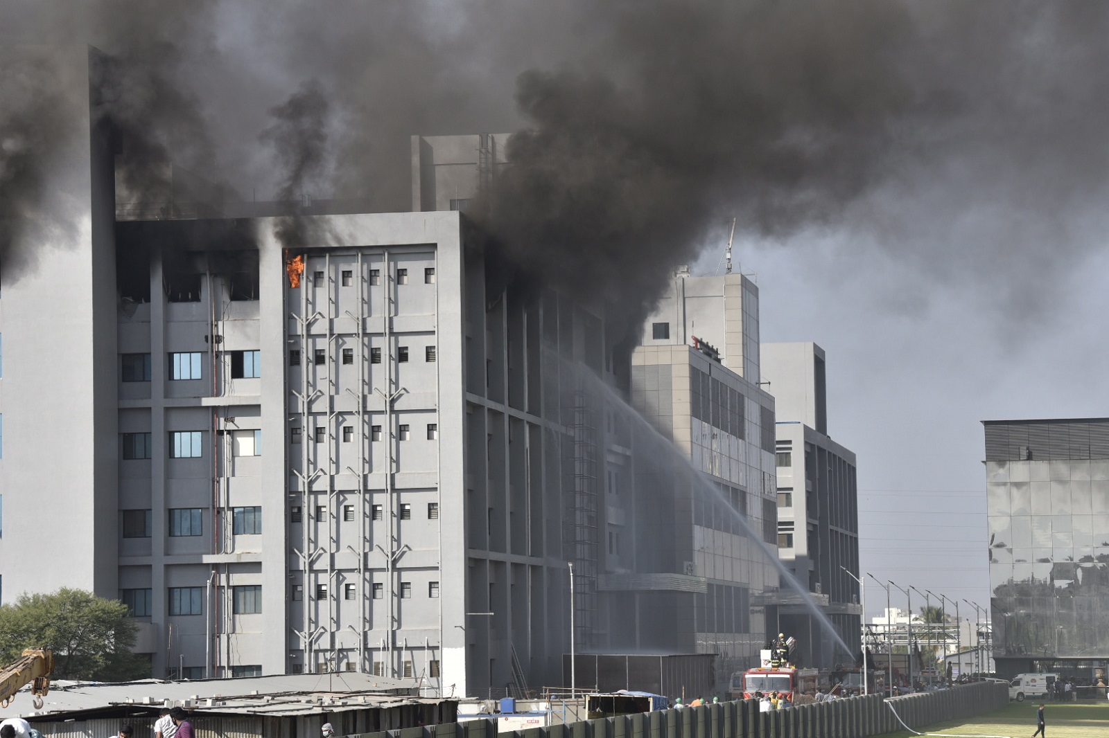 epa08955236 Firefighters try to extinguish a fire at a building of the Covid vaccine-maker Serum Institute of India's Pune facility in Pune Maharashtra, India, 21 January 2021. A massive fire broke out in one of an under construction building of the facility which is spread over 100 acres and no damage and causality reported as many fire engines reached the spot.  EPA/STR